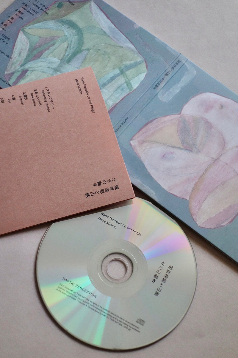 CD with a pink case and colorful packaging on a light surface
