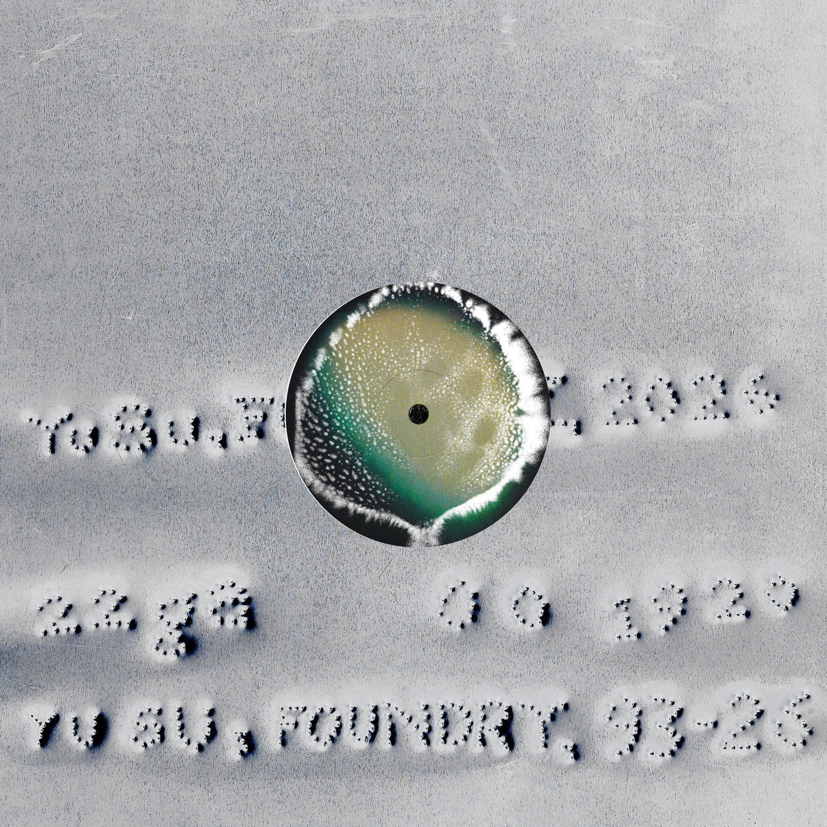 Close-up of a circular object with text around it on a textured surface